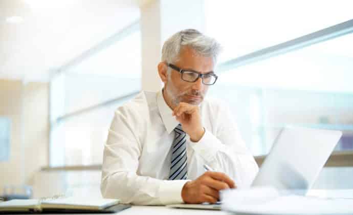 Relaxed mature businessman working in contemporary office